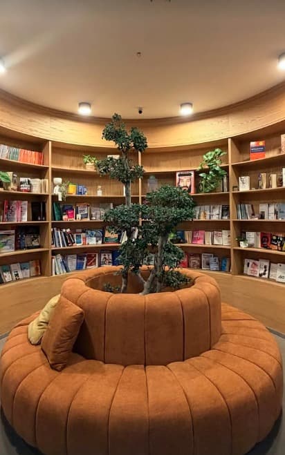 The Notery library — a circular orange lounge seat ringed by book-filled shelves