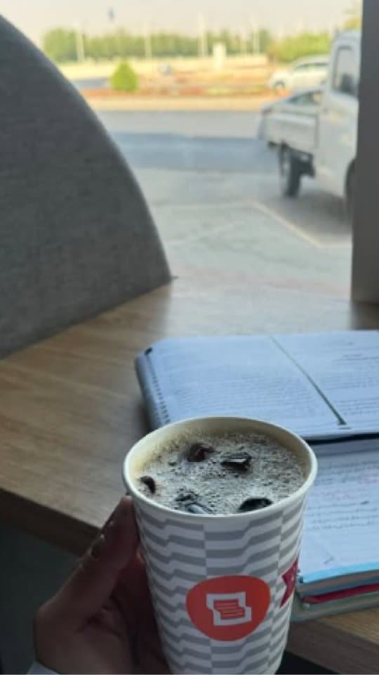 Notery café workspace with coffee and notebook by the window